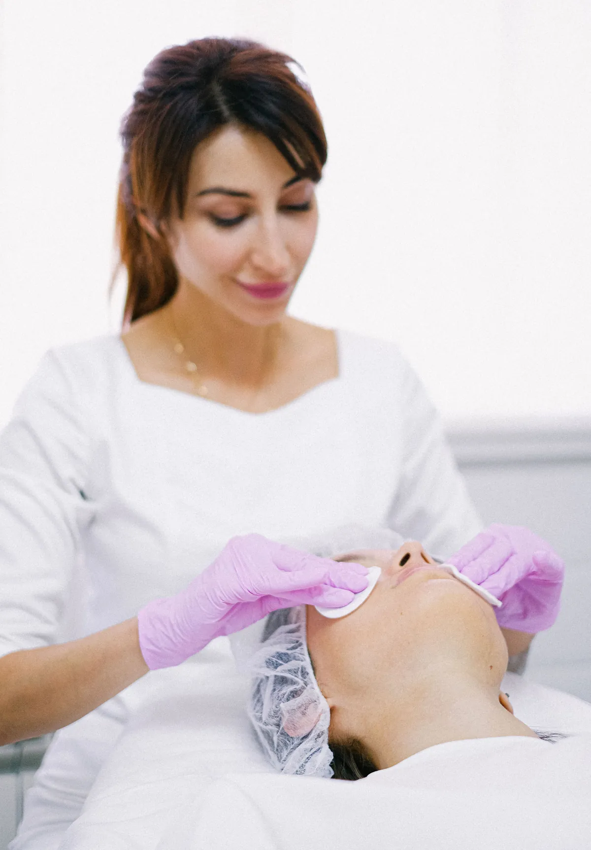 Esthetician examining a client's skin during a consultation