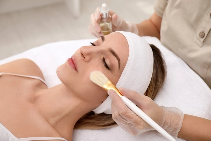 Young woman during face peeling procedure in salon