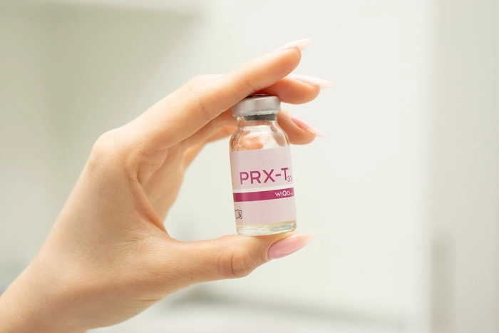 Bottle of peeling PRX-T33 lie in a woman's hand.